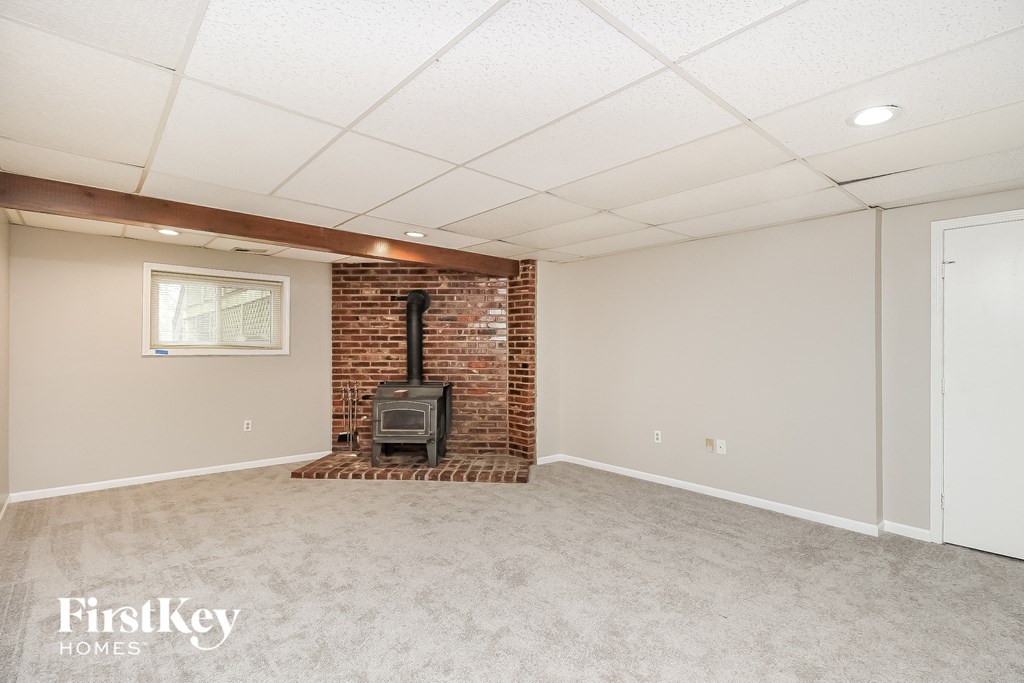 the living room has a brick fireplace and a carpeted floor