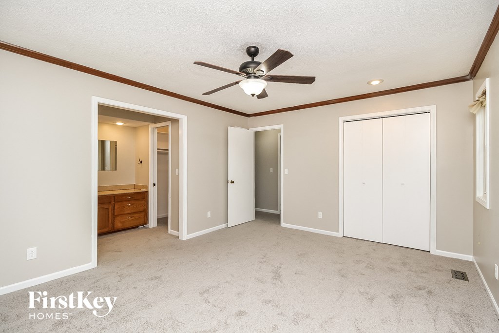 an empty living room with a ceiling fan and a closet