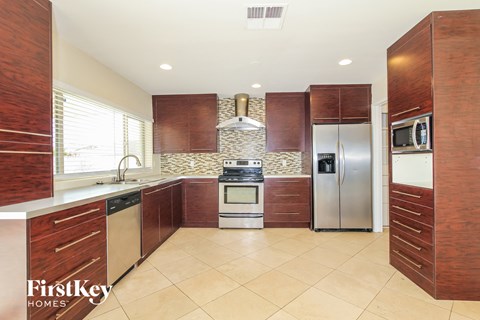A kitchen with wooden cabinets and a tile backsplash.