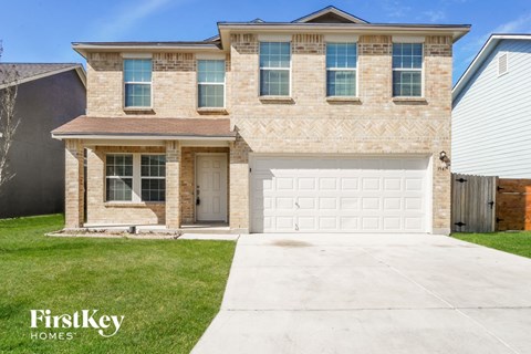 a tan brick house with a white garage door