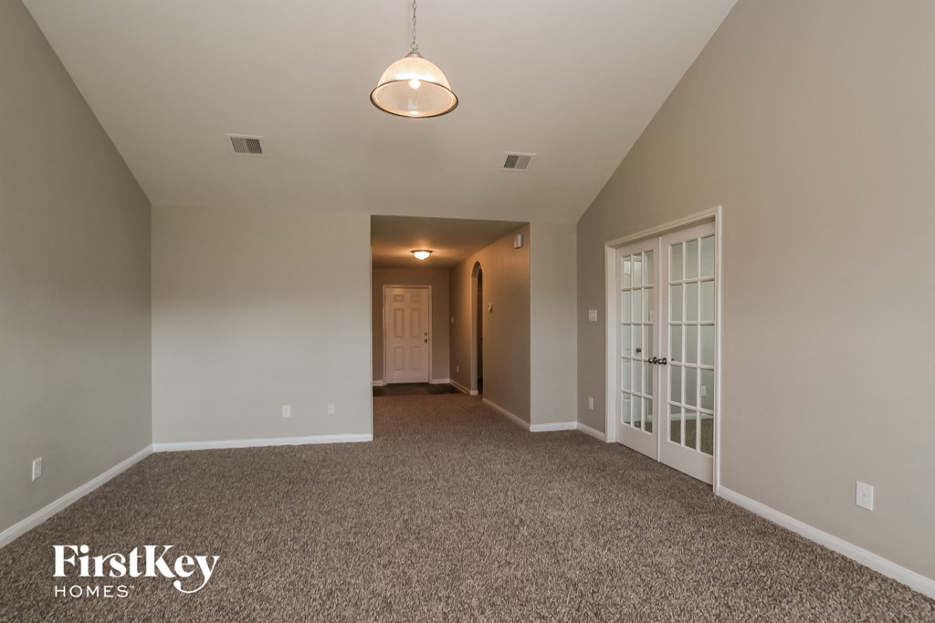 a master bedroom with carpeted flooring and a door to the hallway