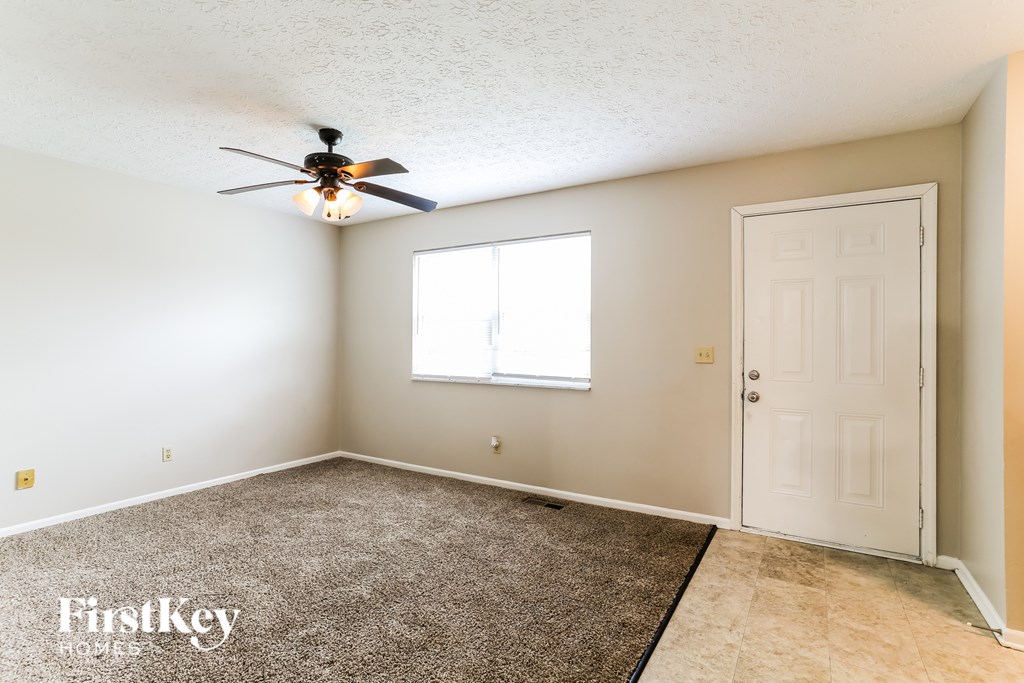 A room with a ceiling fan and a door.