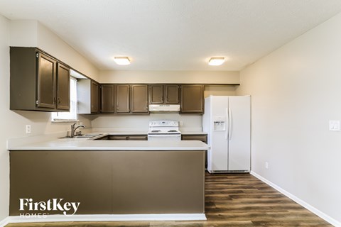 A kitchen with a brown counter and a white fridge.