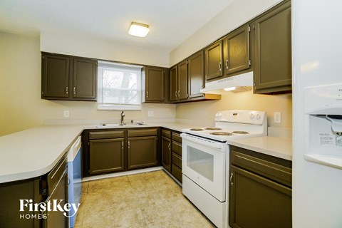 A kitchen with brown cabinets and a white counter top.