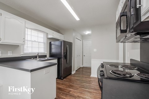 a kitchen with a stove and a refrigerator and a sink