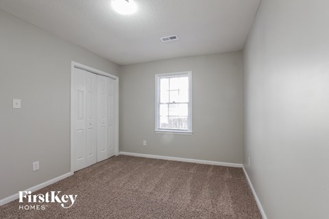 a bedroom with a carpeted floor and a window