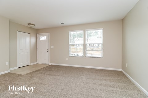 A spacious room with a carpeted floor and two doors.