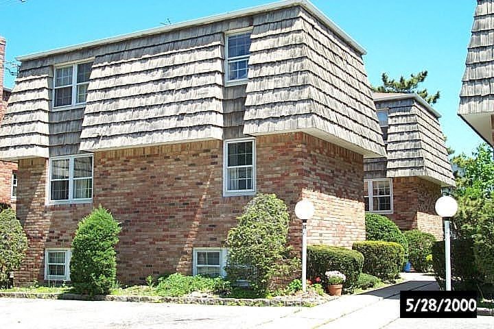 A house with a brick facade and a shingled roof.