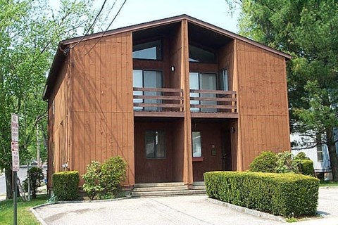 A brown wooden building with a balcony and a door.