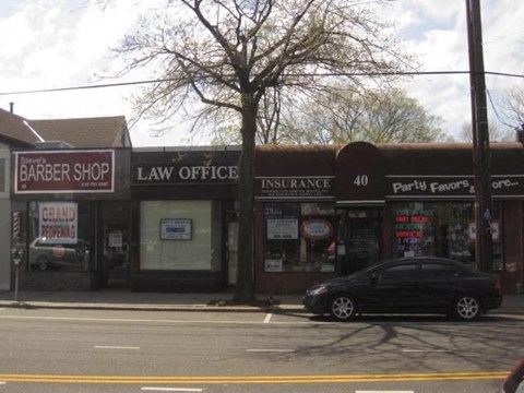 A black car is parked in front of a law office.