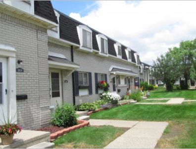 a row of houses with a sidewalk and grass