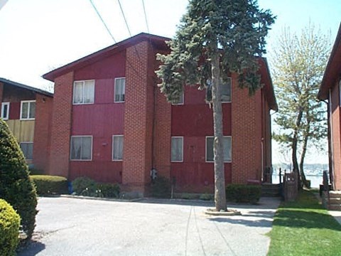 A red brick building with a tree in front.
