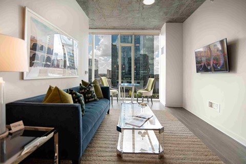 a living room with a blue couch and a large window