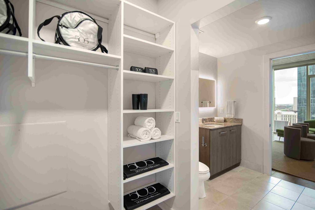 a walk in closet in a bathroom with a toilet and a sink