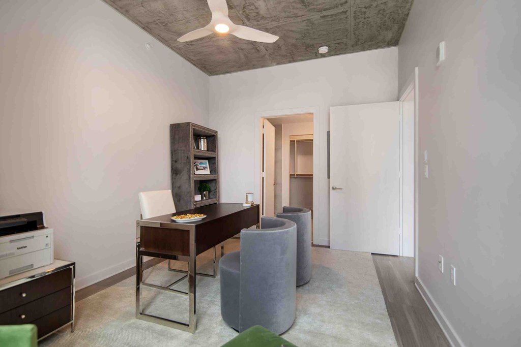 a living room with a table and chairs and a ceiling fan