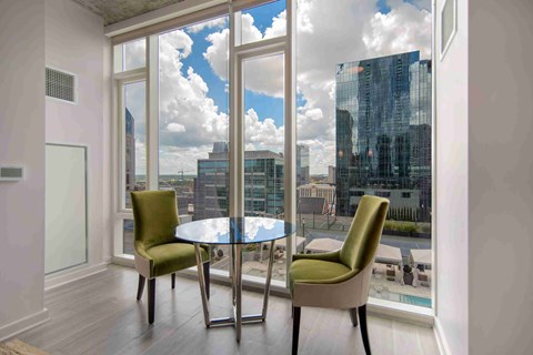 a living room with a table and chairs and a view of the city