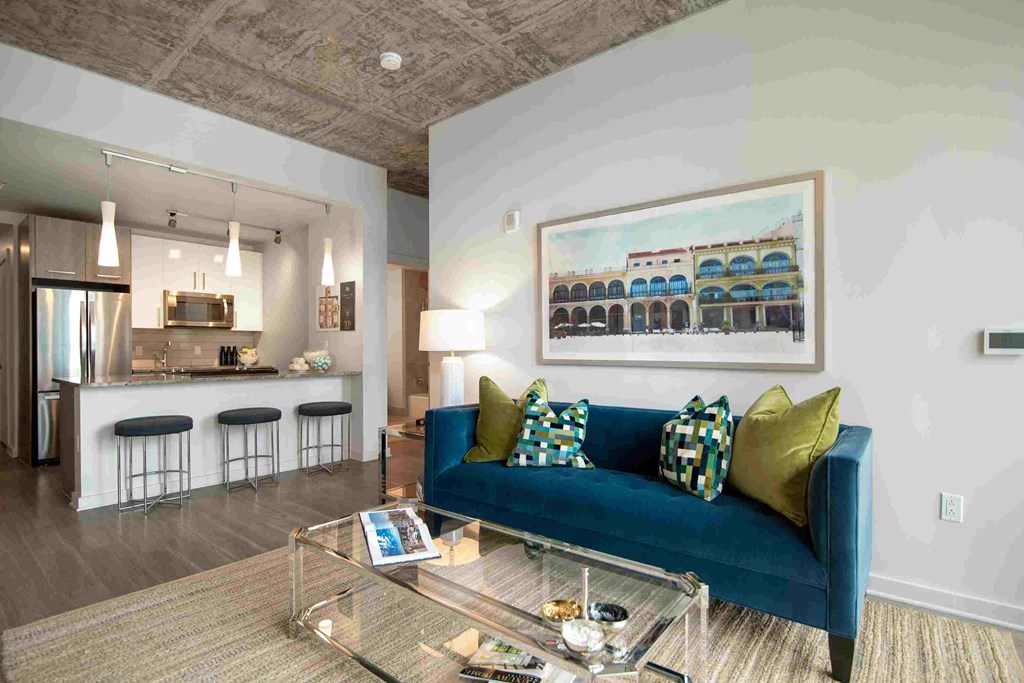 a living room with a blue couch and a glass table