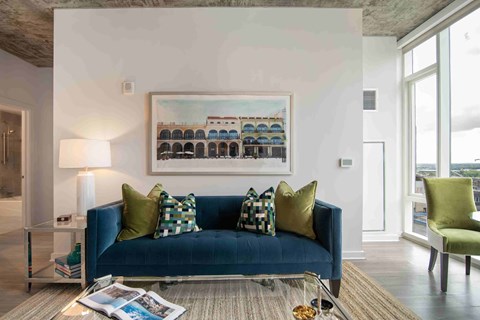 a living room with a blue couch and green pillows