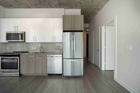 a modern kitchen with stainless steel appliances and white cabinets
