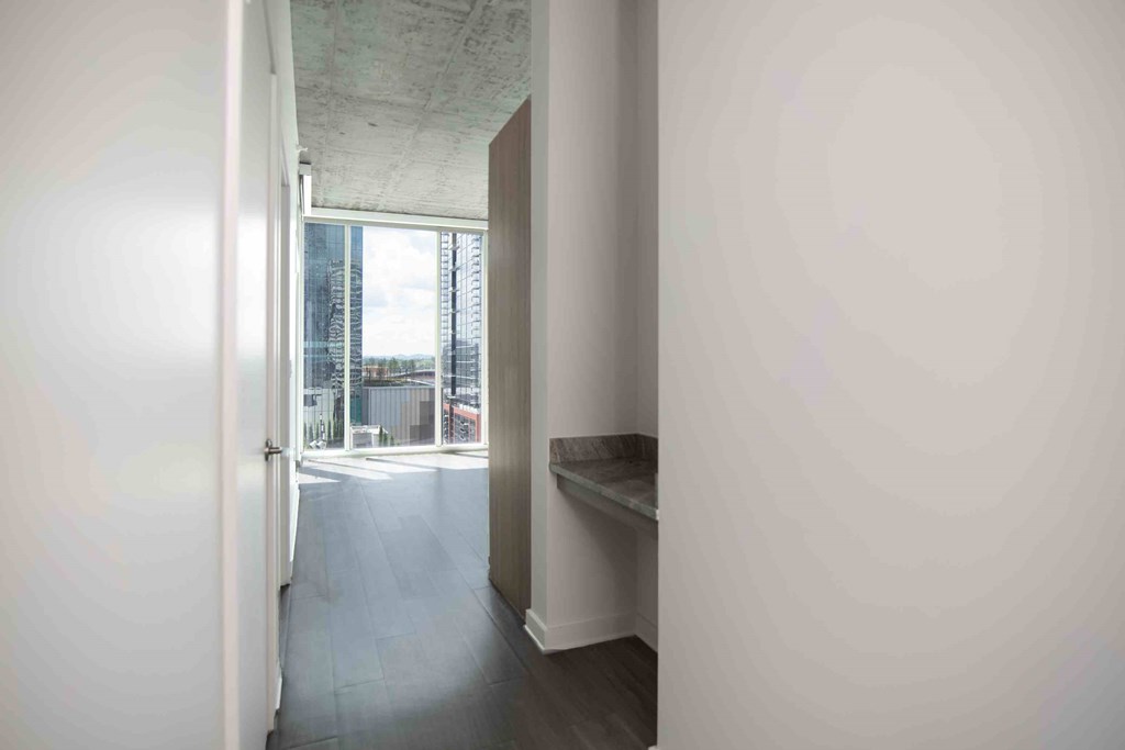 a white hallway with a window and a white door