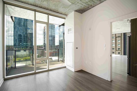 an empty living room with floor to ceiling windows and a balcony