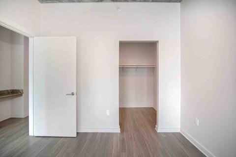 an empty room with white walls and a closet