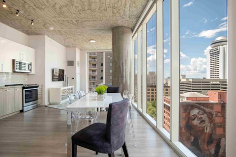 a dining room with a table and chairs and a large window