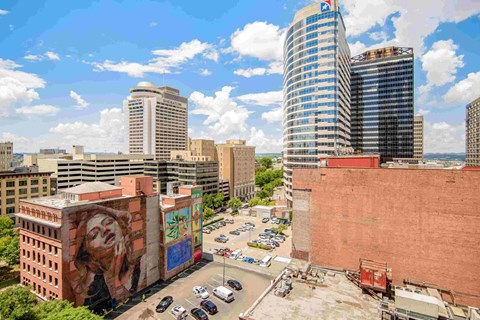 a view of a city with a mural on the side of a building