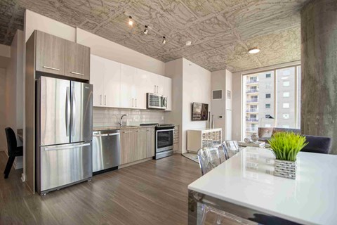 a kitchen with stainless steel appliances and a table and chairs