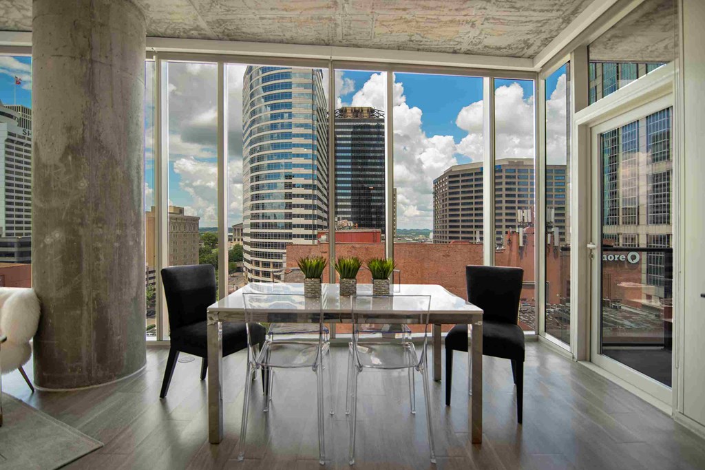a dining room with a table and chairs and a view of the city