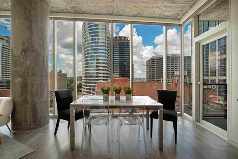 a dining room with a table and chairs and a view of the city