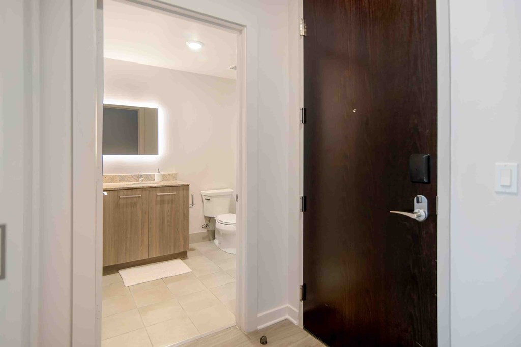 a door leading to a bathroom with a toilet and sink