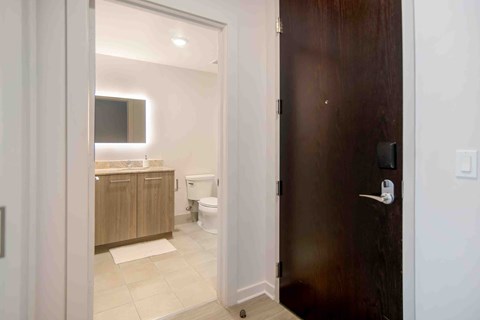 a door leading to a bathroom with a toilet and sink