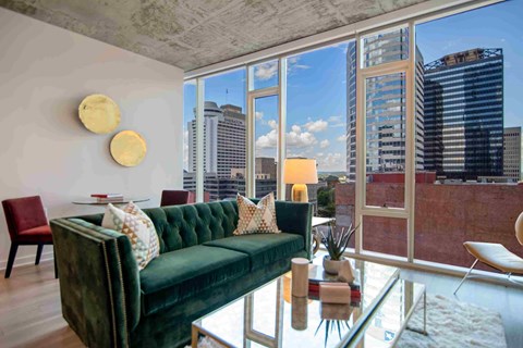 a living room with a green couch and a view of the city