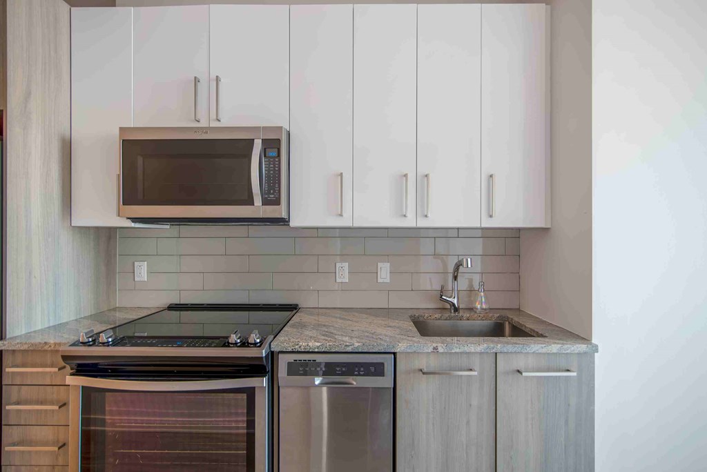 a kitchen with stainless steel appliances and white cabinets