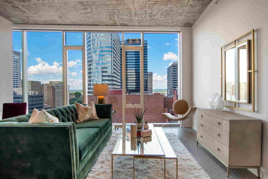 a living room with a green couch and a view of the city