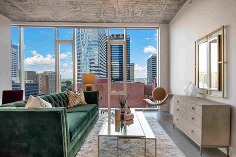 a living room with a green couch and a view of the city
