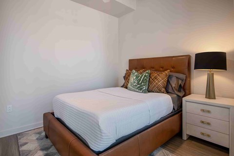 a bedroom with a bed and a nightstand with a lamp