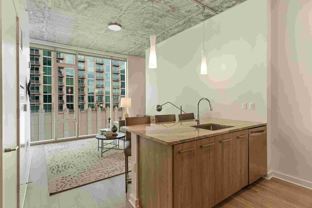 a large kitchen with a large island and a door to the living room