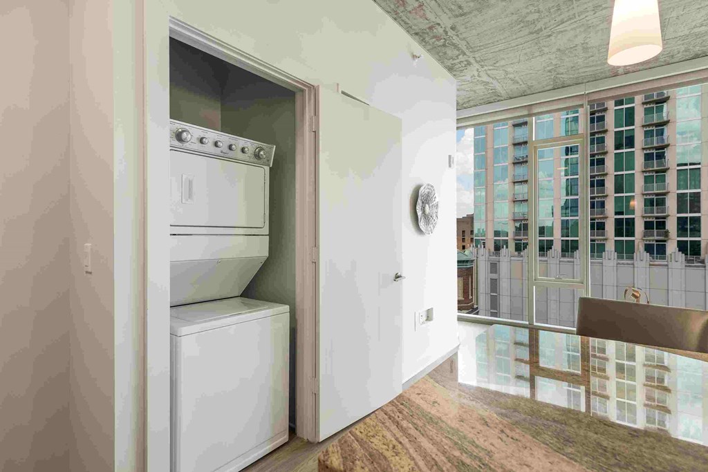 a laundry room with a washer and dryer and a door to a kitchen