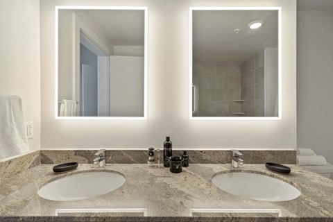 a bathroom with two sinks and two mirrors
