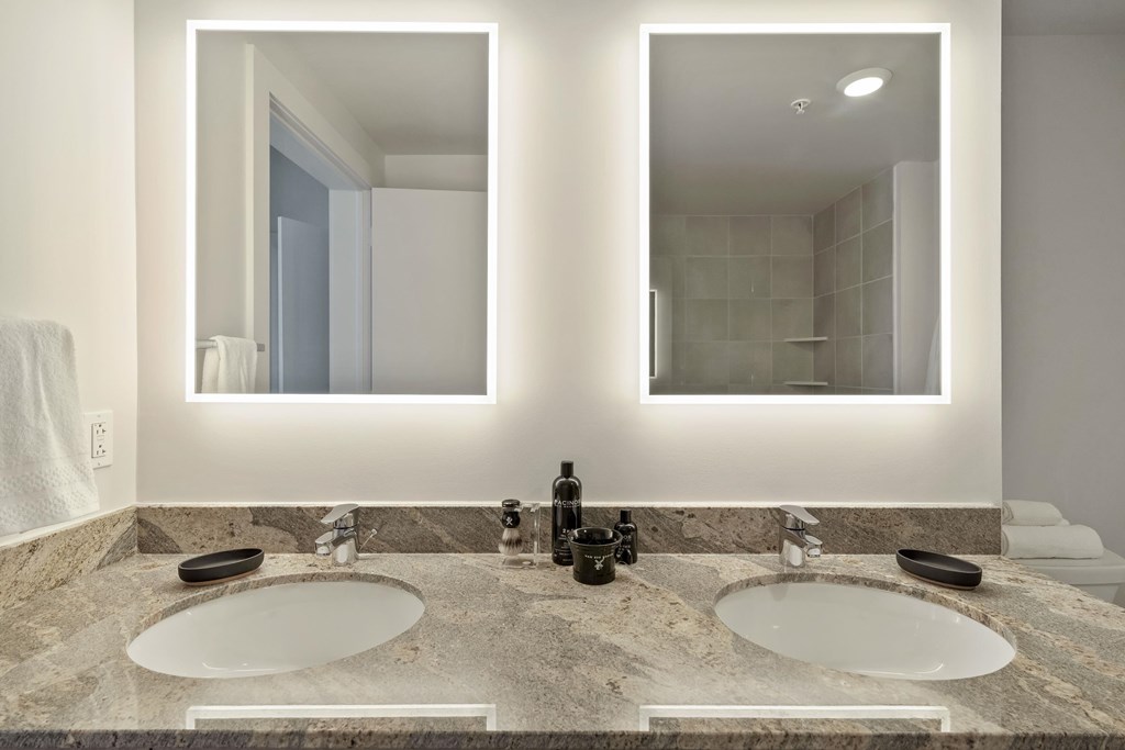 a bathroom with two sinks and two mirrors