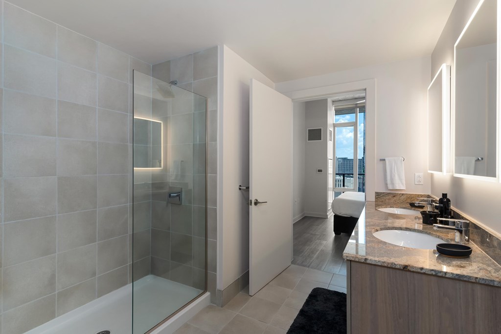 a bathroom with a shower and a sink and a mirror