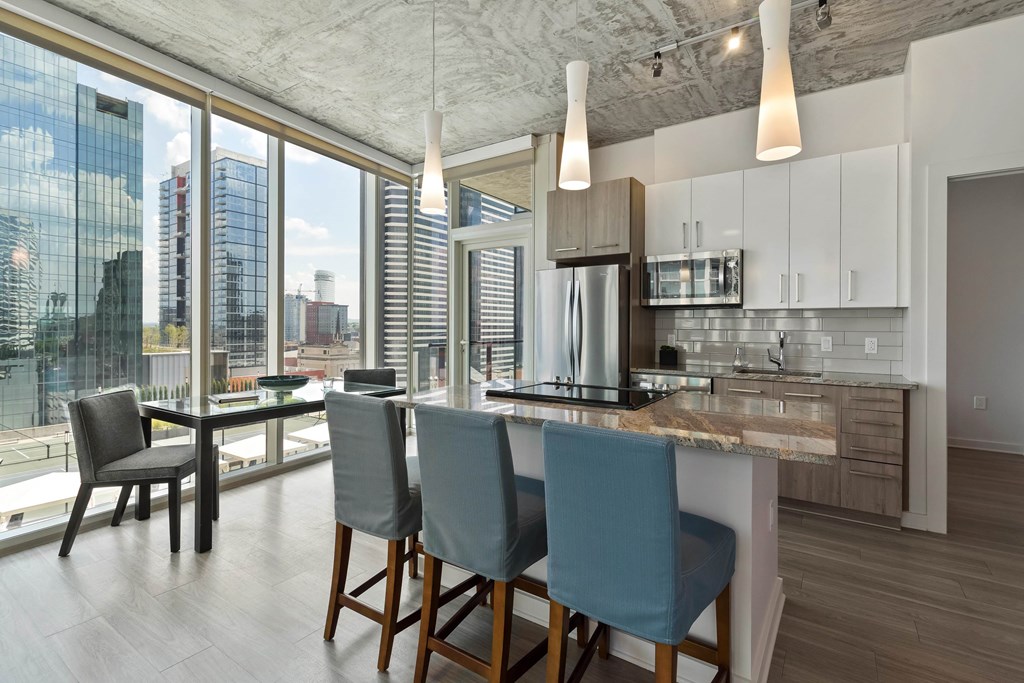 a kitchen with a large island and a table with blue chairs