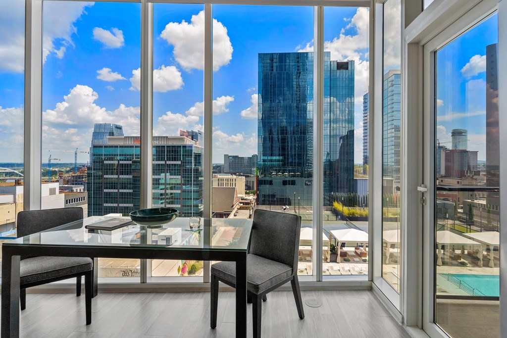 a dining room with a glass table and a view of the city