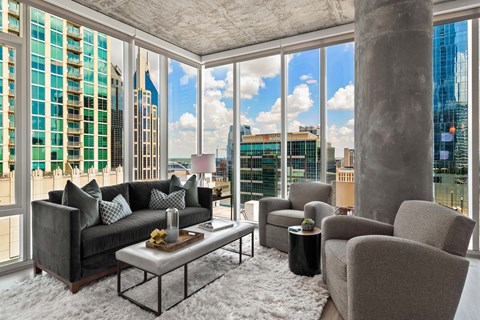 a living room with a view of the city and skyscrapers