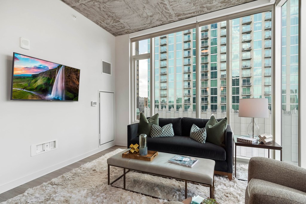 a living room with a large window and a couch and a table