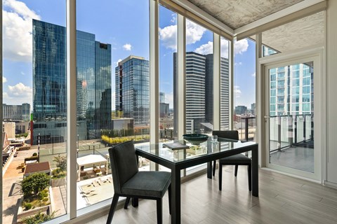 a dining room with a glass table and a view of a city