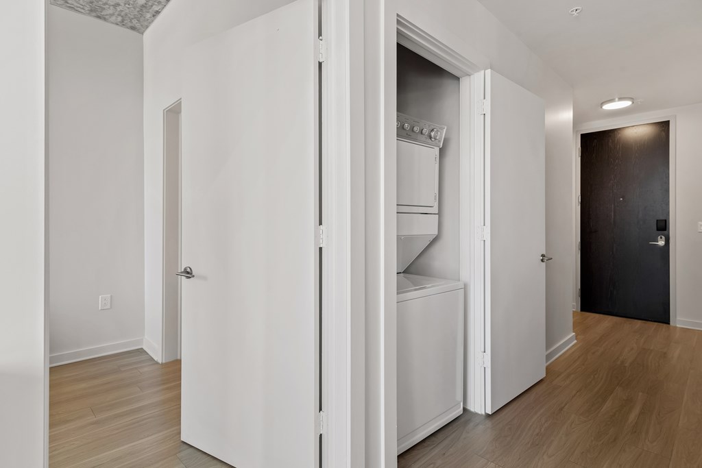 a closet in a living room with a wood floor and white walls