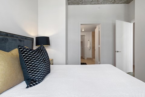 a bedroom with a large bed and a black and white pillow